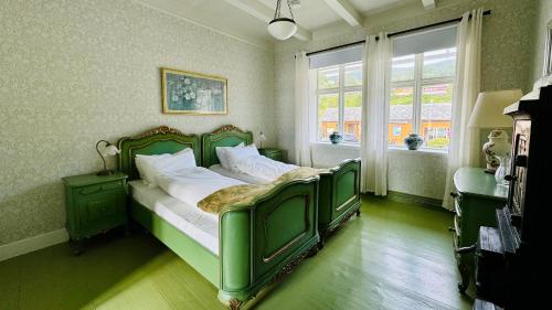 a green bed in a room with a window at Kramsjø Gjestgiveri in Herand