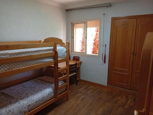 ein Schlafzimmer mit zwei Etagenbetten und einem Fenster in der Unterkunft Appartement de luxe Résidence Majorelle in Marrakesch