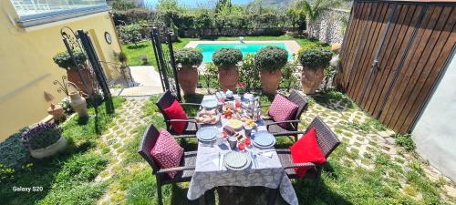 a table and chairs in a backyard with a pool at Villa Caruso in Massa Lubrense