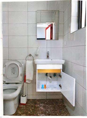 a bathroom with a toilet and a sink and a mirror at First HR Hotel in Prampram