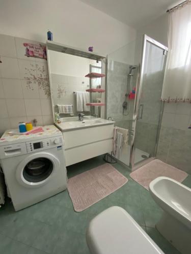 a bathroom with a washing machine and a sink at Appartamento Trifoglio in Salò