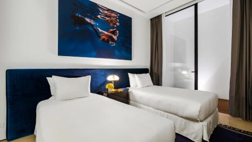 a hotel room with two beds and a painting on the wall at PIER 57 - 710 Fabulous & Luxurious 2 BR Penthouse in Puerto Vallarta