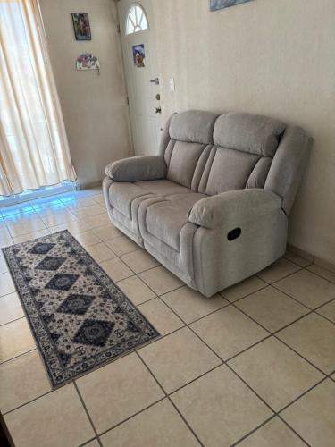 a living room with a couch and a tile floor at Depa Mosu in Guanajuato