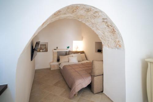 een slaapkamer met een bed en een boog bij Trulli Magda in Martina Franca