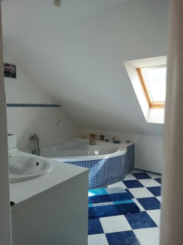 a bathroom with a tub and a sink and a window at U Cáfi Valtice in Břeclav