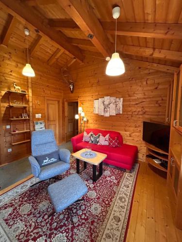 a living room with a red couch and a table at Blockhäuser Stamsried in Stamsried