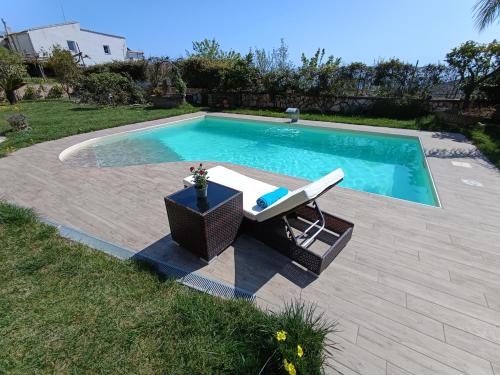 a swimming pool with a table and a chair next to it at Villa Caruso in Massa Lubrense