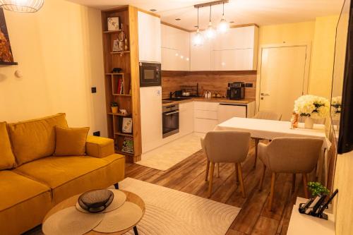 a living room with a couch and a table and a kitchen at Tirol Home -Green Apartment in Veliko Tŭrnovo