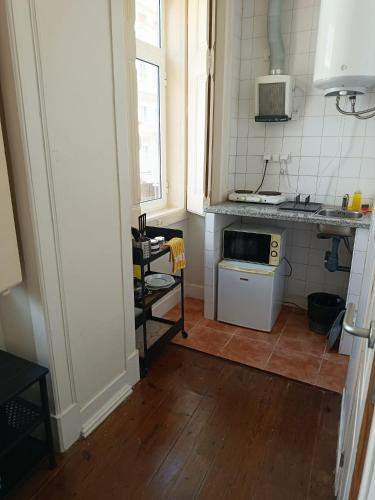 a small kitchen with a sink and a microwave at Amoreiras Lisbon Apartments in Lisbon