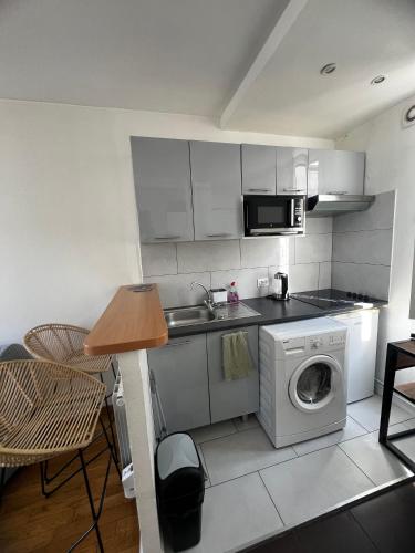 une petite cuisine avec une machine à laver et un évier dans l'établissement Appartement Parisian Chic, à Paris