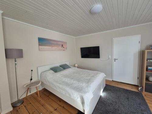 a bedroom with a bed and a flat screen tv at Sonnige Ferienwohnung I in Harrislee
