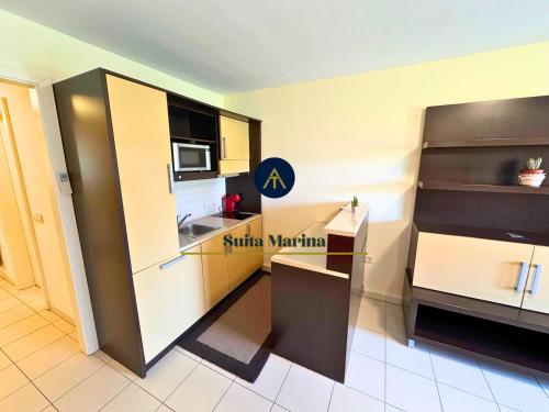 a small kitchen with a refrigerator and a microwave at SUITA MARINA - Near Beach with Terrace & 2 Parking Spaces at Marina Portoroz in Portorož