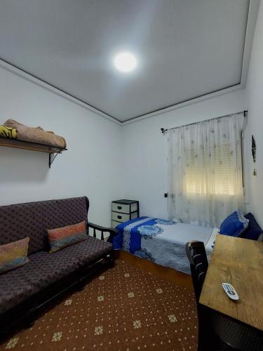 a living room with a couch and a bed at Cozy Room & Modern Amenities 3 in Tetouan