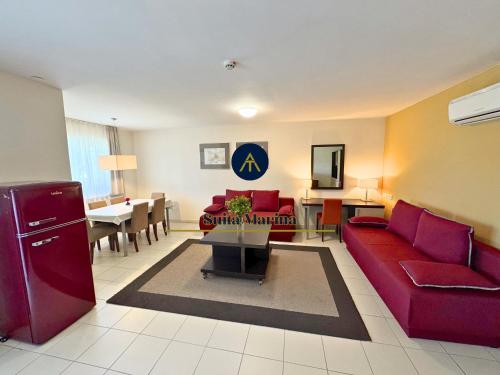 a living room with a red couch and a dining room at SUITA MARINA - Near Beach with Terrace & 2 Parking Spaces at Marina Portoroz in Portorož