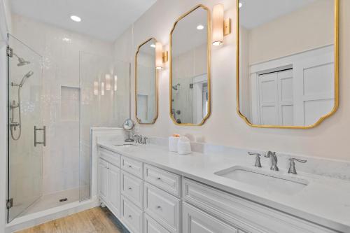 un bagno bianco con due lavandini e due specchi di Island Blue At Destin Pointe Resort a Destin