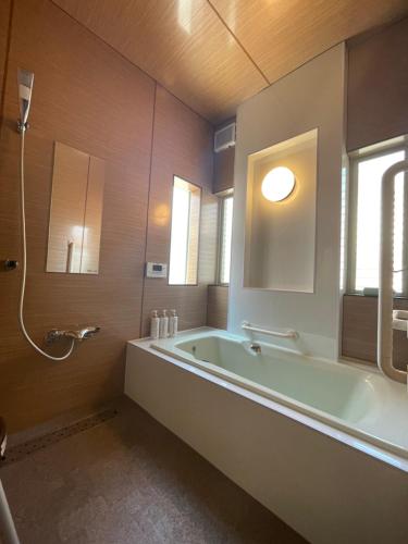 a large bathroom with a tub and a window at A Beautiful Large Japanese Home with Tatami room in Shizuoka