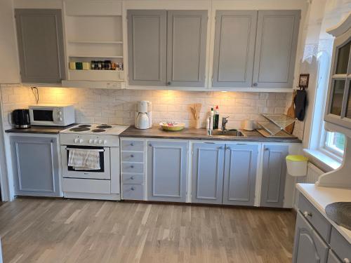 a kitchen with white cabinets and a stove top oven at Blanka10 in Blankaholm