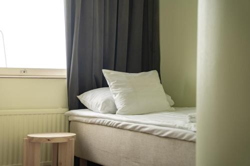 a bed with a pillow on it next to a window at Luovo in Marjaniemi
