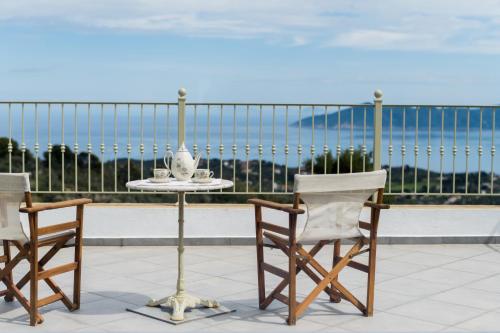 a table and two chairs on a balcony at Aegean Breeze Skiathos in Skiathos Town