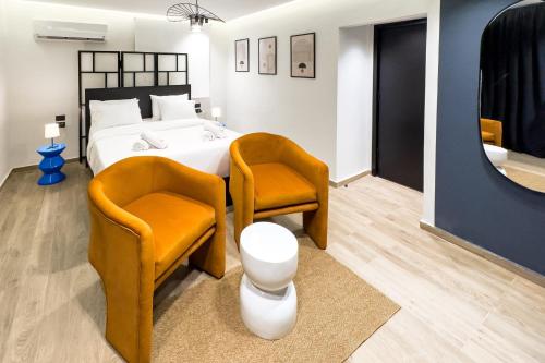 a bedroom with two orange chairs and a bed at The 2 BDR Sapphire Condo 5 min to CAI Airport in Cairo