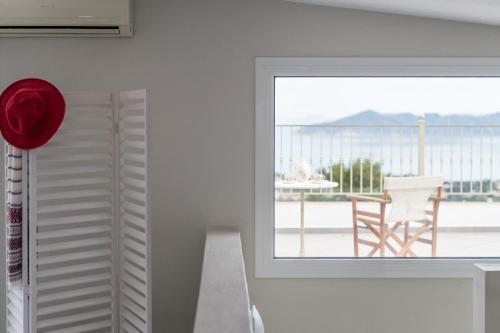 a room with a window and a table with a chair at Aegean Breeze Skiathos in Skiathos Town