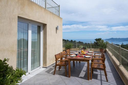 a table and chairs on the balcony of a house at Aegean Breeze Skiathos in Skiathos Town