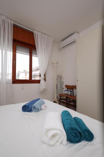 a bedroom with a bed with towels on it at Oasi blu - Charme nel cuore della pineta in Grado-Pineta