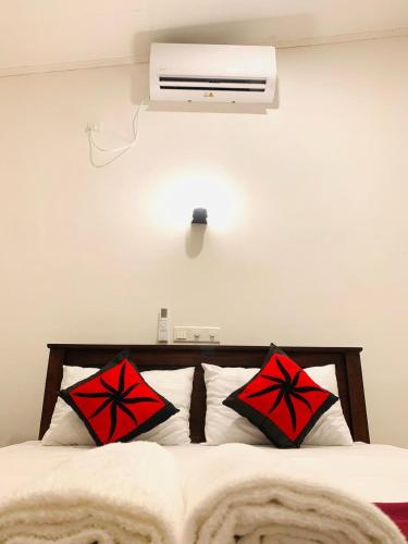 a bedroom with a bed with red and black pillows at Waves in Hikkaduwa