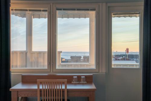 a table with a view of the ocean through windows at Luovo in Marjaniemi