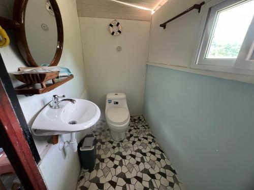 a small bathroom with a toilet and a sink at Baan Plai Laem Homestay at Koh Paluay in Koh Phaluai