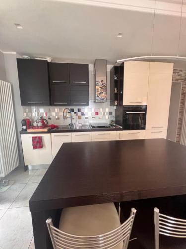 a kitchen with a black table and chairs at Casa Yuliya with lake view! in Regoledo