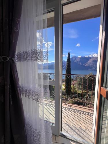 a sliding glass door with a view of the mountains at Casa Yuliya with lake view! in Regoledo