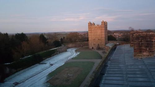 a castle with a road next to a building at Appleby Castle in Appleby
