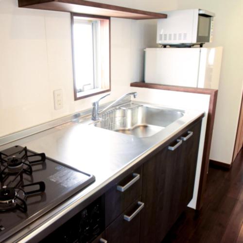 a kitchen with a sink and a stove at Scallop Beach Condominium in Onna