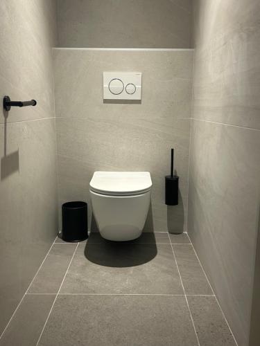 a bathroom with a white toilet in a room at Hôtel Doussière - Restaurant l'Alicanta in Le Rozier