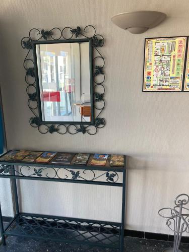 a mirror on a wall next to a shelf at HOTEL RESTAURANT Chez Nous in Fitou