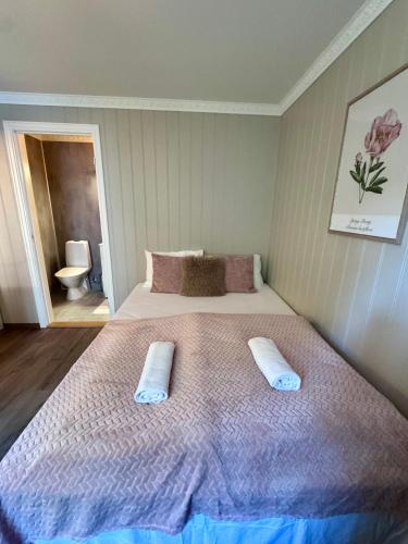 a bedroom with a large bed with two pillows on it at Bispen Villa Utsikten in Åndalsnes