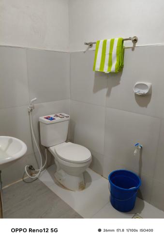 a bathroom with a white toilet and a sink at Rubilla's Homestay in Mambajao