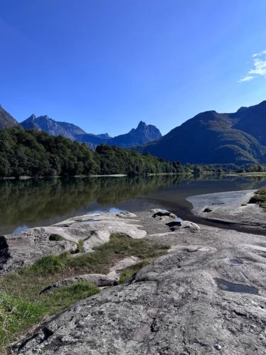 a river with trees and mountains in the background at Bispen Villa Utsikten in Åndalsnes