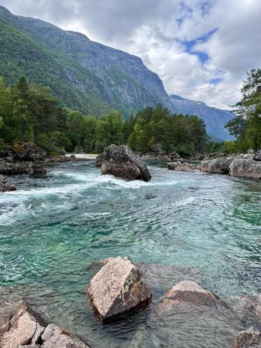 a river with rocks in front of a mountain at Bispen Villa Utsikten in Åndalsnes