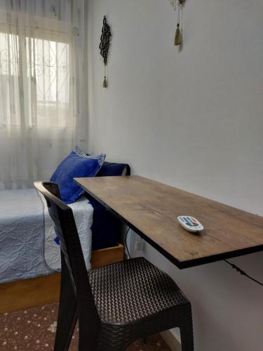 a wooden desk with a chair and a bed at Cozy Room & Modern Amenities 3 in Tetouan