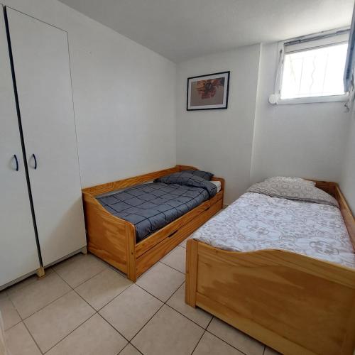 une chambre avec deux lits et une fenêtre dans l'établissement T3 au bord de l'étang de Thau, à Balaruc-les-Bains