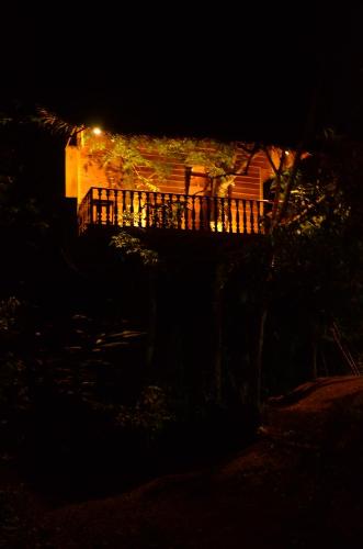 a house at night with a fence in front of it at Tree House-Midigama in Weligama