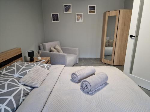a bedroom with a bed with two towels on it at Mario Leśny Klif 21 in Debina