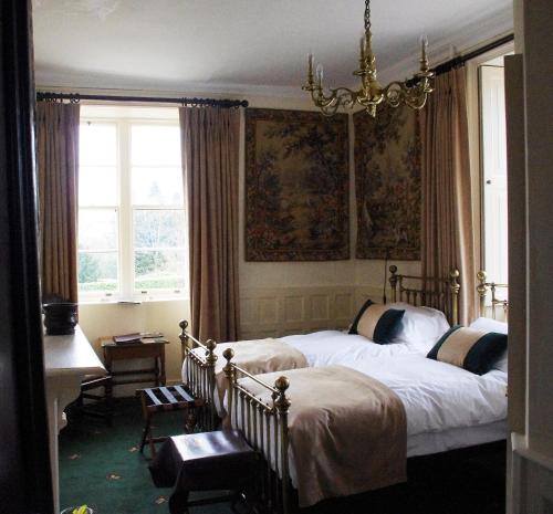 a bedroom with two beds and a chandelier at Appleby Castle in Appleby