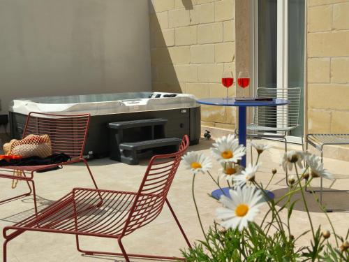 a patio with two chairs and a grill with two glasses of wine at Alba in Sliema