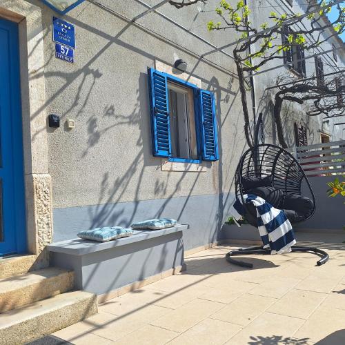 a bench next to a building with a blue window at Calma di Medulin in Medulin