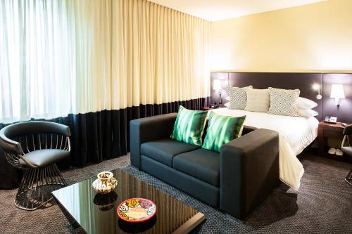 a hotel room with a bed and a couch at Movich Buro 26 in Bogotá