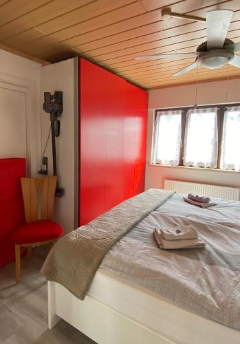 a bedroom with a bed with a red wall at 3 Zimmer Ferienwohnung Freiendiez in Diez
