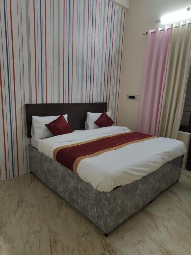 a bedroom with a large bed with red pillows at Veer Guest House in Bareilly